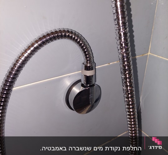 צינור מתכת מחובר לקיר בחדר אמבטיה
